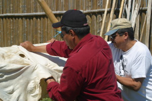 Earl Cheechoo (in red) and Bert Chilton drying and stretching a moose hide